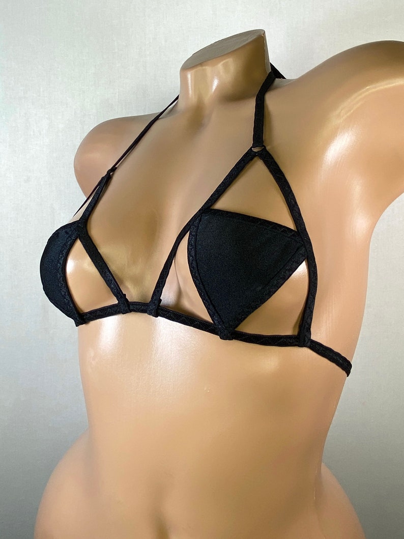 May include: Black triangle-shaped bra with a criss-cross design and adjustable straps.