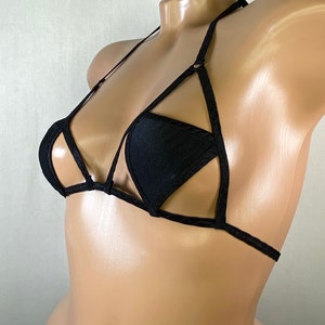 May include: Black triangle-shaped bikini top with a criss-cross design and adjustable straps.