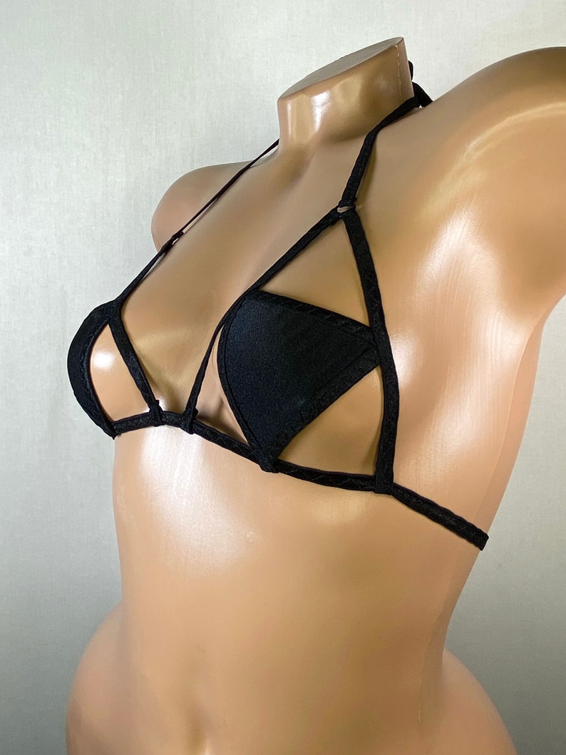 May include: Black triangle-shaped bikini top with a criss-cross design and adjustable straps.