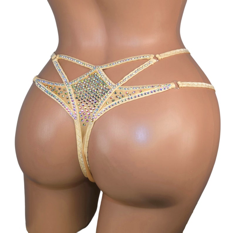 Puede incluir: Lingerie de malla beige con un dise&ntilde;o geom&eacute;trico que presenta un gran grupo de piedras de imitaci&oacute;n iridiscentes.