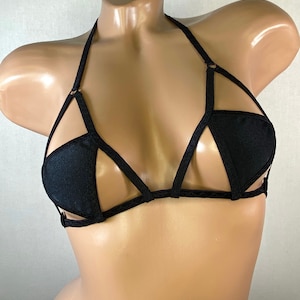 May include: Black lingerie bra with a geometric design and thin straps.