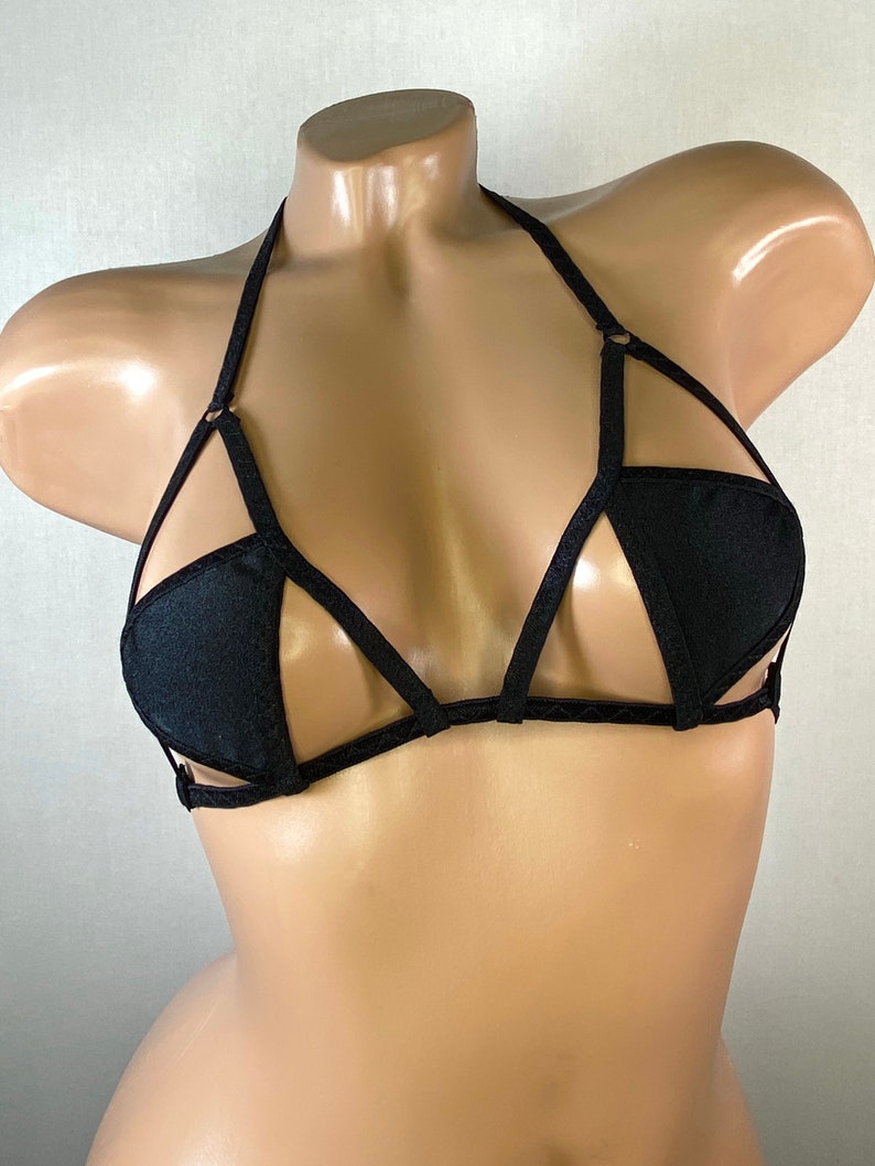 May include: Black lingerie bra with a geometric design and thin straps.