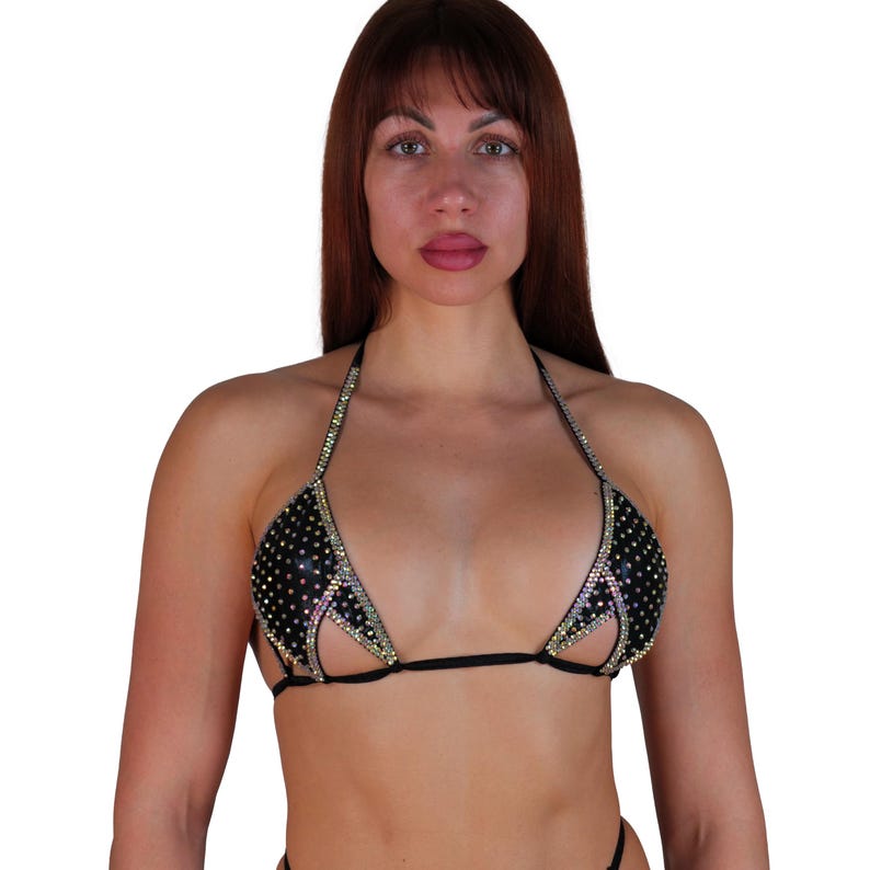 Pu&ograve; includere: Un top bikini nero con un design a taglio e strass.