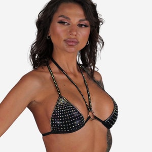 K&ouml;nnte beinhalten: Ein schwarzer Bikini-Oberteil mit Dreiecksform und einem Halfterriemen. Das Oberteil ist mit schillernden Strasssteinen besetzt.