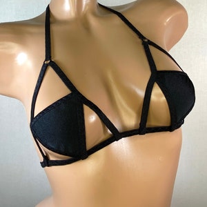 May include: Black lingerie bra with a geometric design and thin straps.