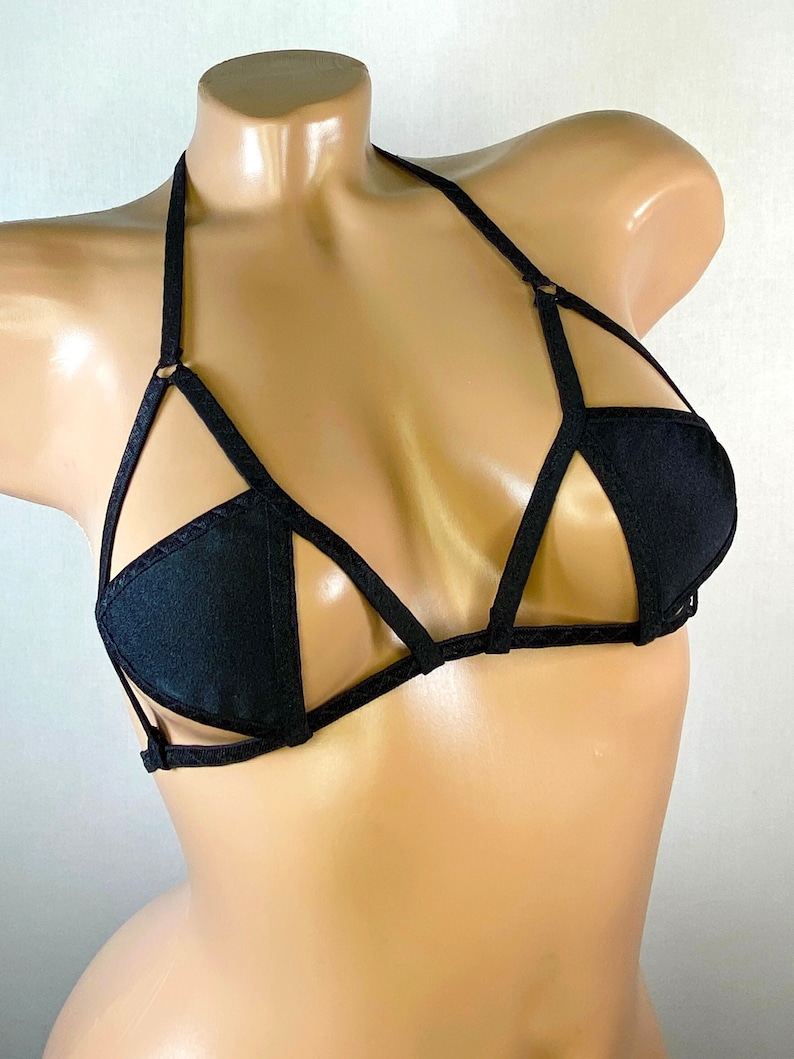 May include: Black lingerie bra with a criss-cross strap design and a triangular cut-out in the center.