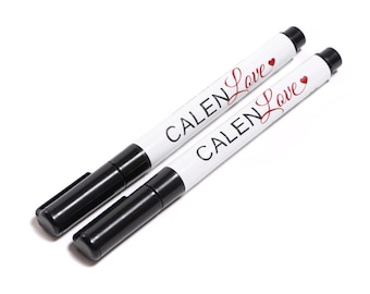May include: Two black permanent markers with white labels that say "CALEN Love" with a red heart symbol.
