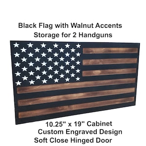 May include: A rectangular wall-mounted cabinet featuring a black and walnut wood American flag design. The cabinet measures 10.25 inches by 19 inches, includes a soft-close hinged door, and provides storage for two handguns with custom engraved details.