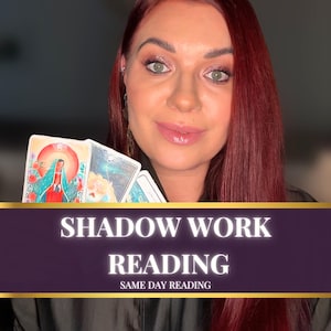 May include: A woman with red hair holds tarot cards. The cards feature colorful illustrations. Text on a banner reads "SHADOW WORK READING" and "SAME DAY READING". The woman is smiling at the camera.