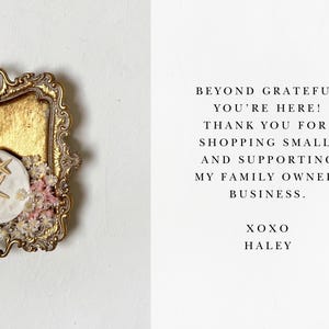 Pode incluir: Uma bandeja dourada com um prato de cer&acirc;mica branca com duas estrelas do mar. A bandeja &eacute; decorada com flores secas. O texto no cart&atilde;o diz: "Beyond grateful you're here! Thank you for shopping small and supporting my family owned business. XOXO Haley."