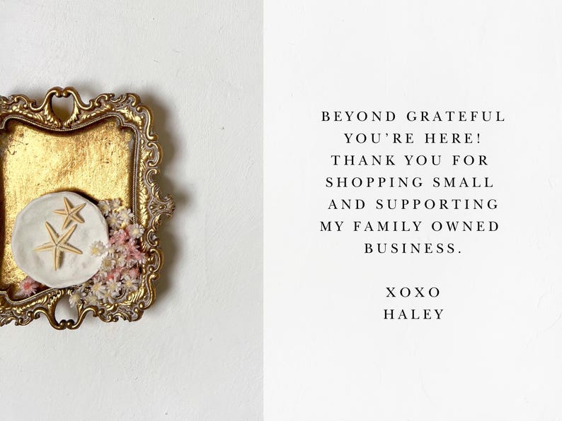 Pode incluir: Uma bandeja dourada com um prato de cer&acirc;mica branca com duas estrelas do mar. A bandeja &eacute; decorada com flores secas. O texto no cart&atilde;o diz: "Beyond grateful you're here! Thank you for shopping small and supporting my family owned business. XOXO Haley."