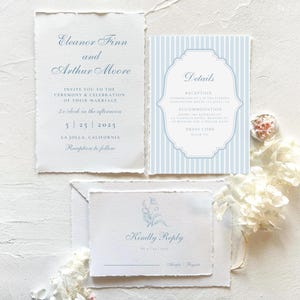 Pode incluir: Conjunto de convites de casamento com um design listrado azul e branco. O cart&atilde;o de convite apresenta os nomes "Eleanor Finn e Arthur Moore" e a data "5.25.2025". O cart&atilde;o RSVP tem um design floral e o texto "Kindly Reply".