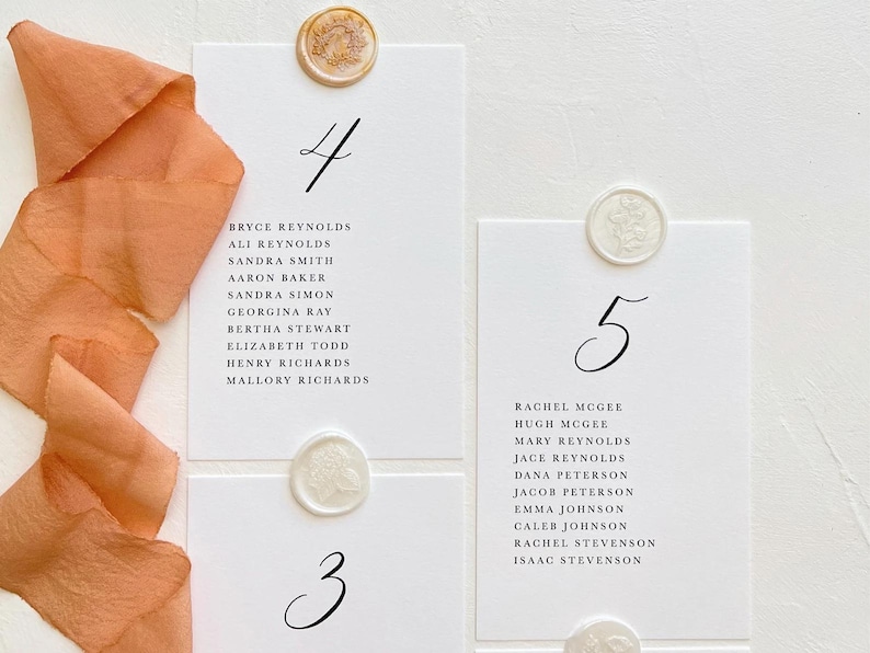 May include: White cards with black calligraphy numbers 3, 4, and 5. Each card has a list of names. The cards are decorated with wax seals.