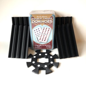 May include: A box of double twelve dominoes with 91 high quality color-dot dominoes. The box is red, white, and blue with the words "Family Classics Double Twelve Dominoes" printed on it. The dominoes are white with black dots.