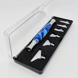 May include: A blue and white swirl patterned tool with a silver tip and a black case with 7 additional tips.
