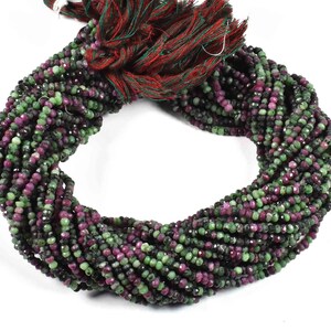 Könnte beinhalten: Eine Strähne aus grünen und rosafarbenen Edelsteinperlen. Die Perlen sind facettiert und haben eine leicht unregelmäßige Form. Die Strähne ist etwa 45 cm lang.