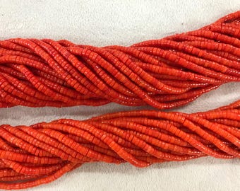 Puede incluir: Primer plano de hebras de pequeñas cuentas rectangulares de color naranja brillante. Las cuentas están fuertemente ensartadas, creando una apariencia texturizada en forma de cuerda. Las cuentas son de un color vibrante y sólido, y la imagen está bien iluminada.