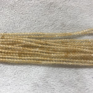 Puede incluir: Una hebra de cuentas translúcidas de color ámbar claro. Las cuentas son redondas y tienen un acabado liso y pulido.