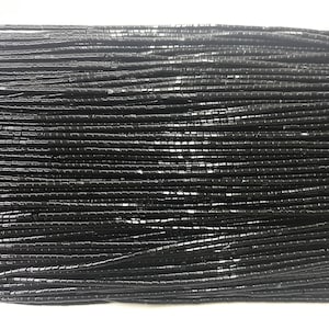 Puede incluir: Una hebra de cuentas cuadradas negras, cada cuenta mide aproximadamente 6 mm de largo.