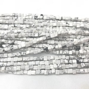 Puede incluir: Una hebra de cuentas cuadradas blancas y negras hechas de piedra natural. Las cuentas miden aproximadamente 6 mm y tienen un acabado liso y pulido.