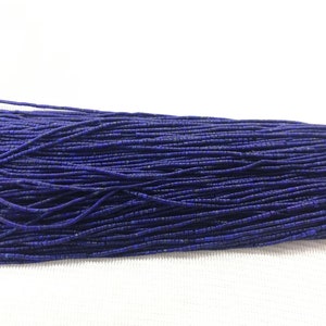 Könnte beinhalten: Eine Strähne tiefblauer Lapislazuli-Perlen, jede Perle ist klein und rechteckig.