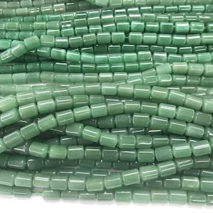 Può includere: Una collana di perle di giada verde chiaro, ogni perla ha una forma rettangolare liscia.