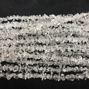 Puede incluir: Una hebra de cuentas de cuarzo transparente en forma de chips. Las cuentas son irregulares en forma y tamaño, y tienen un acabado natural sin pulir.