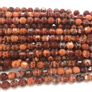 Peut inclure: Un brin de perles d'agate facettées dans des tons de brun, orange et rouge. Les perles ont un motif marbré unique.