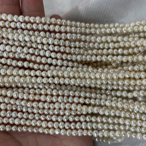Peut inclure: Un brin de perles d'eau douce blanches, chaque perle est ronde et lisse. Les perles sont enfilées sur un fil fin et sont prêtes à être utilisées pour la fabrication de bijoux.