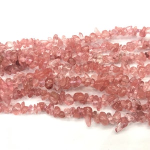 Puede incluir: Una hebra de cuentas de chips de cuarzo rosa. Las cuentas son irregulares en forma y tamaño, y tienen un acabado natural y pulido.