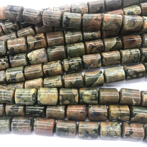 May include: A strand of green, brown, and white jasper beads. The beads are cylindrical and have a mottled pattern.