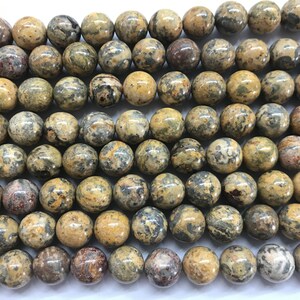 Op de afbeelding: Een streng ronde, bruine, grijze en zwarte jaspis kralen. De kralen zijn ongeveer 10 mm in diameter en hebben een gevlekt, gespikkeld uiterlijk.