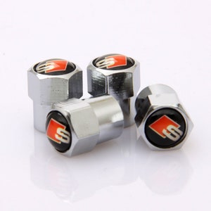 May include: Four silver tyre valve stem caps with a red and black Audi S logo.