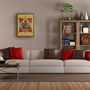 K&ouml;nnte beinhalten: Ein wei&szlig;es Sofa mit roten und braunen Kissen steht in einem Wohnzimmer mit einem B&uuml;cherregal aus Holz, das mit B&uuml;chern und Dekorationsgegenst&auml;nden gef&uuml;llt ist. &Uuml;ber dem Sofa h&auml;ngt ein gerahmtes religi&ouml;ses Symbol.