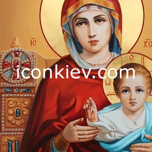May include: A religious icon depicting the Virgin Mary holding baby Jesus. Mary is wearing a red robe with a gold trim and a blue veil. Jesus is wearing a white robe with a blue outer garment. The icon is painted on a gold background with a halo around Mary and Jesus.