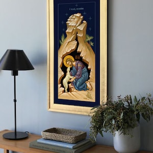 K&ouml;nnte beinhalten: Eine gerahmte religi&ouml;se Ikone, die Jesus Christus in einer H&ouml;hle mit einem Lamm darstellt. Die Ikone ist in traditionellem Stil mit goldenen Akzenten und blauem Hintergrund gemalt. Der Text "&Omicron; &Kappa;&Alpha;&Lambda;&Omicron;&Sigma; &Pi;&Omicron;&Iota;&Mu;&Eta;&Nu;" ist in Griechisch oben auf der Ikone geschrieben.