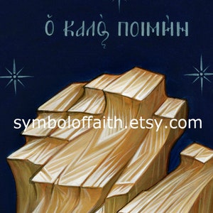 K&ouml;nnte beinhalten: Ein Gem&auml;lde eines Holzkreuzes mit dem griechischen Text "&oacute; kal&oacute;s poim&eacute;n" (Der gute Hirte) dar&uuml;ber. Das Kreuz ist in einem hellen Braunton gemalt und vor einem dunkelblauen Hintergrund mit wei&szlig;en Sternen platziert.