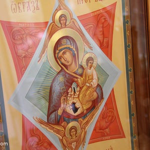 K&ouml;nnte beinhalten: Eine religi&ouml;se Ikone, die die Jungfrau Maria zeigt, die das Jesuskind h&auml;lt. Die Ikone ist in traditionellem Stil mit goldenen Akzenten und blauem Hintergrund gemalt. Die Jungfrau Maria tr&auml;gt eine blaue Robe und eine goldene Krone. Das Jesuskind tr&auml;gt eine wei&szlig;e Robe und eine goldene Krone. Die Ikone ist in einem Holzrahmen gerahmt.