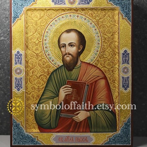 May include: Hand-painted icon of Saint Basil, a religious figure, depicted with a book and a cross. The icon is framed in a gold-leafed wooden frame with intricate floral designs. The background is a golden colour with a halo around the saint's head.