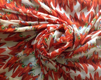 May include: White fabric with a red chili pepper print. The fabric is gathered and twisted, creating a swirling pattern.
