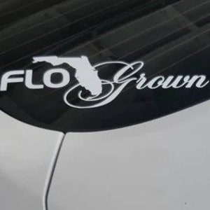 Op de afbeelding: Witte vinyl sticker met de tekst "FLO Grown" en een omtrek van de staat Florida.