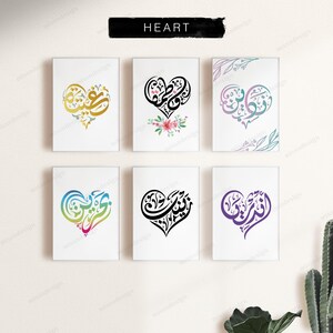 May include: Six rectangular wall art prints arranged in two rows, each featuring Arabic calligraphy shaped into a heart. The designs include gold, black with pink flowers, pastel gradient, blue-to-pink gradient, solid black, and purple ink colors.