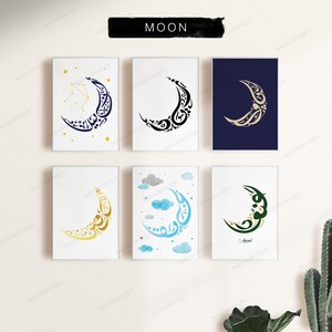May include: Six rectangular wall art prints arranged in two rows, each featuring a crescent moon formed by Arabic calligraphy. Designs include gold stars on white, black ink on white, gold on navy, gold on white, blue clouds on white, and green on white.