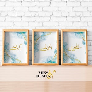 Peut inclure: Trois impressions encadrées avec un fond aquarelle bleu et une calligraphie dorée. Les impressions présentent les mots arabes "Allah", "Alhamdulillah" et "Insha'Allah".