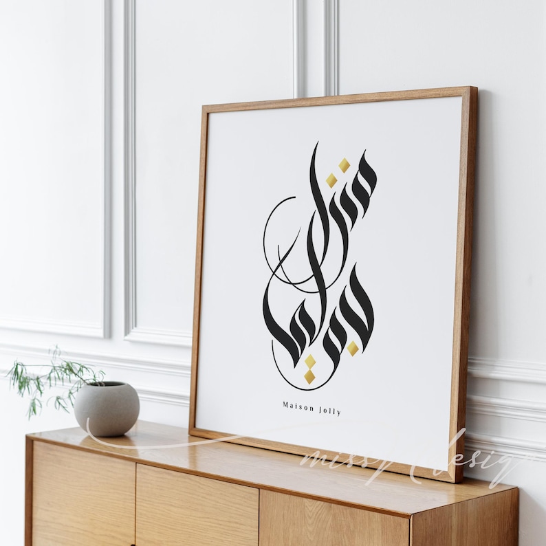 Puede incluir: Una impresi&oacute;n art&iacute;stica enmarcada con un dise&ntilde;o de caligraf&iacute;a abstracta en negro y dorado sobre un fondo blanco. La obra de arte incluye el texto "Maison Jolly". El marco es de madera clara.