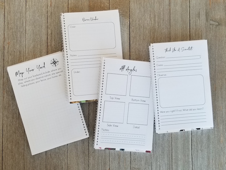 May include: Four spiral-bound notebooks with white pages and black text. The notebooks have prompts like "Map Your Yard", "Over/Under", "All Angles", and "Think Like A Scientist". The notebooks are on a wooden surface.