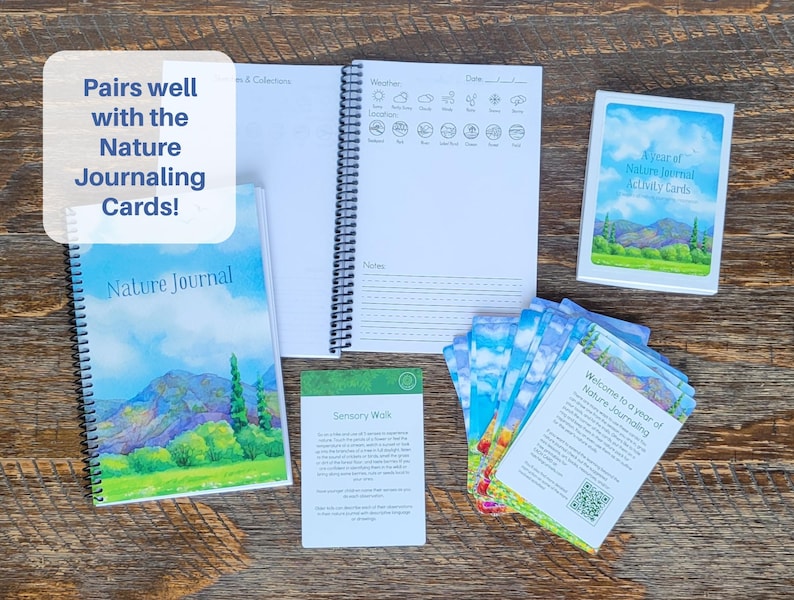May include: A collection of nature journaling supplies, including a spiral-bound journal with a landscape illustration, a set of activity cards, and a notebook with weather and notes sections. The text "Pairs well with the Nature Journaling Cards!" is visible.