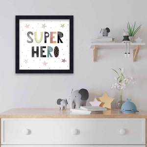 May include: A black framed print with the words "SUPER HERO" in colorful, patterned letters. The print is surrounded by small black stars on a white background.