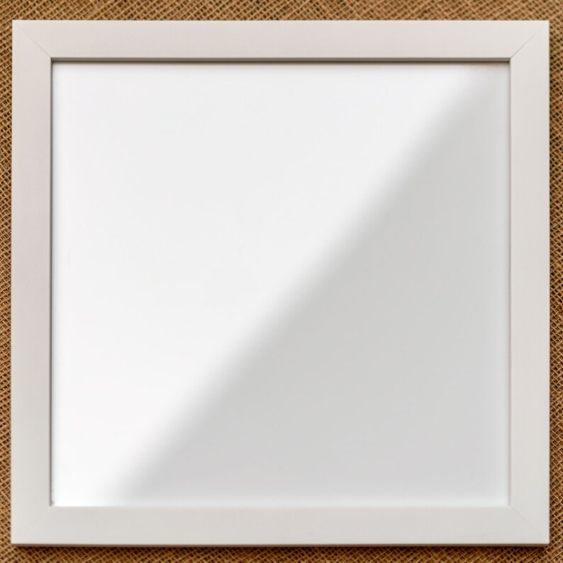 May include: A square wall mirror featuring a clean, white frame with a smooth finish. The reflective glass surface is clear and flat, capturing a bright light reflection across the center, set within a simple, uniform border design.