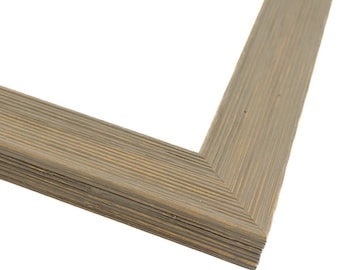 May include: A close-up of a corner of a wood picture frame with a rustic, weathered gray finish. The frame has a layered, multi-dimensional look.